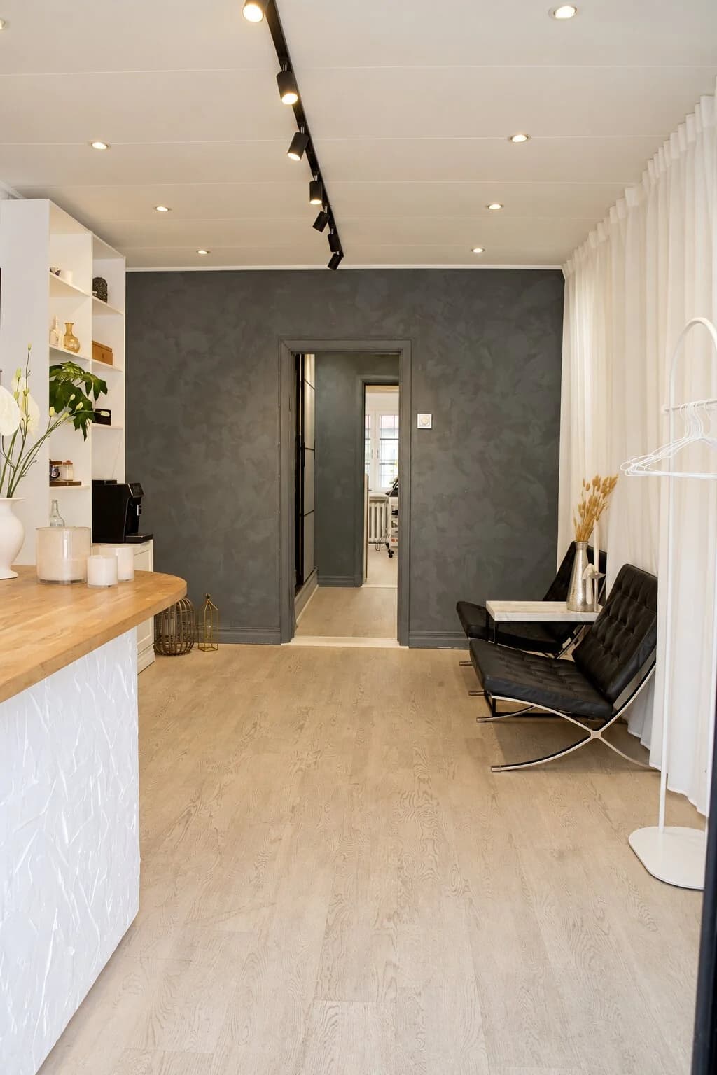 Receptionen hos Avat Clinic med disk i ek, sittgrupp och ljusa gardiner